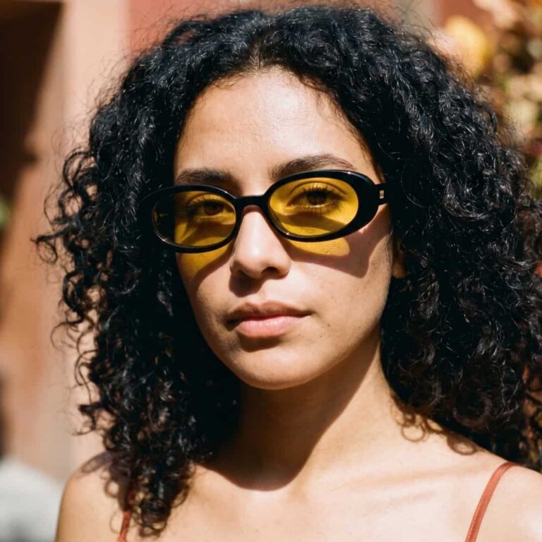 Lunettes de soleil rétro Le Specs modèle Outta Love monture noire avec verres ambrés jaunes.