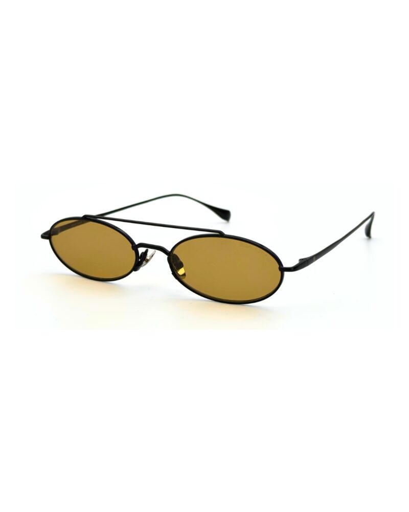 Homme au style urbain portant des lunettes de soleil BLUE EYES noires, monture fine à double pont et verres ambre clair.