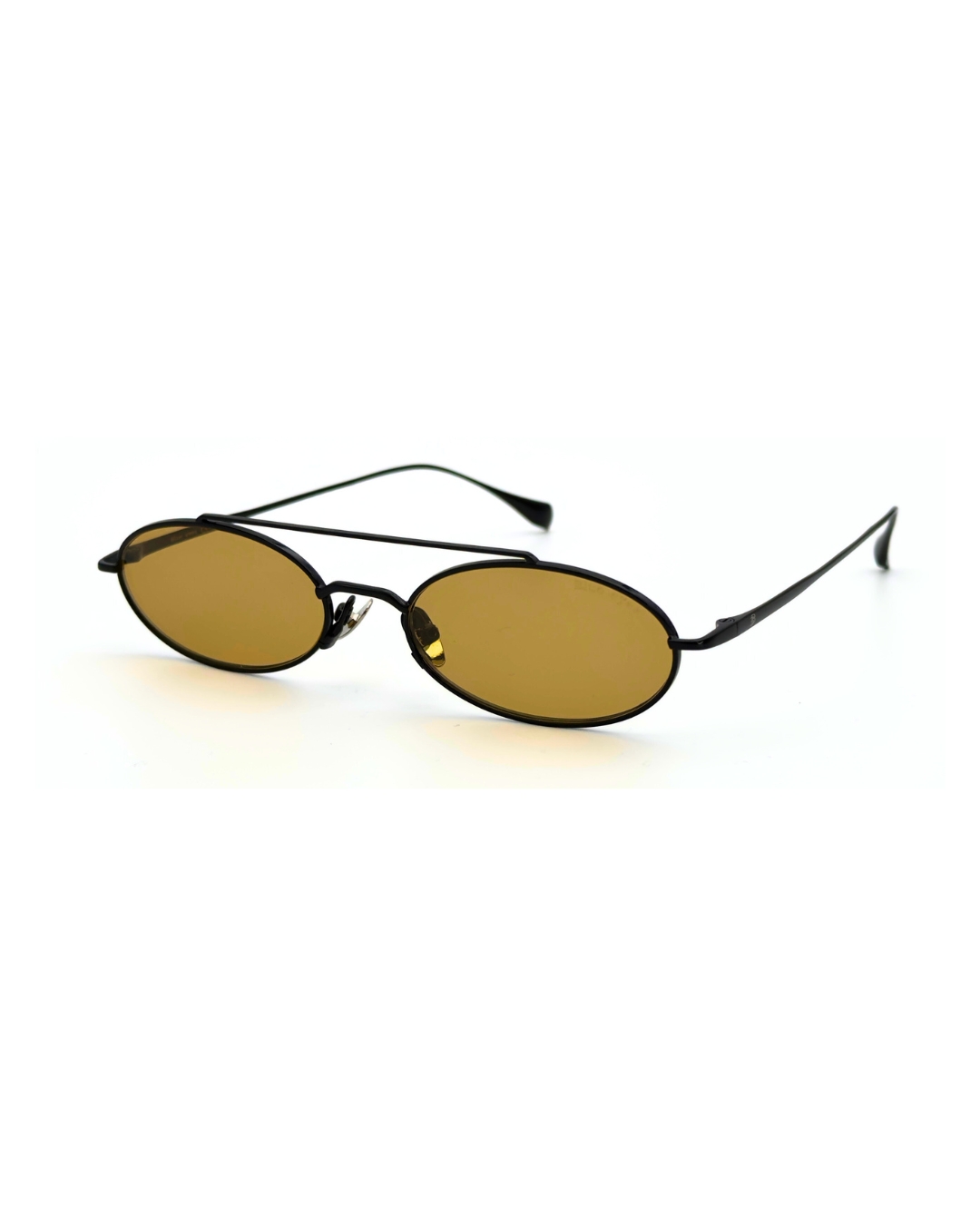 Homme au style urbain portant des lunettes de soleil BLUE EYES noires, monture fine à double pont et verres ambre clair.