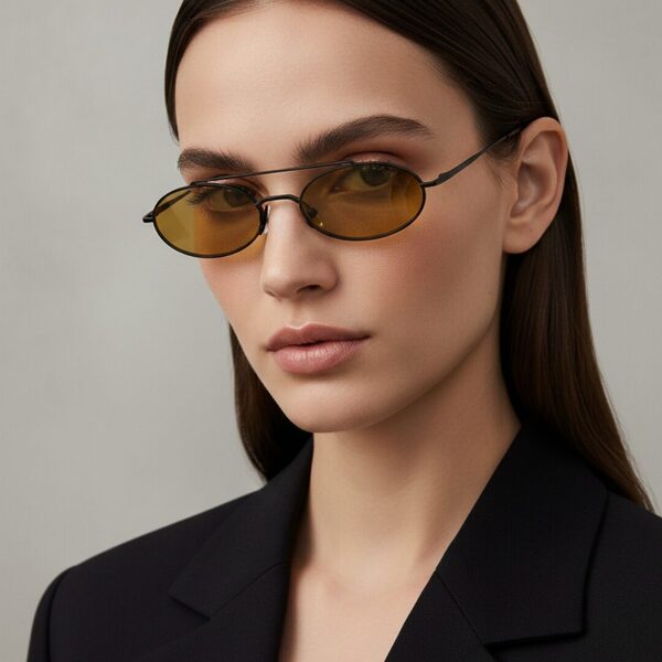 Femme au style urbain portant des lunettes de soleil BLUE EYES noires, monture fine à double pont et verres ambre clair.