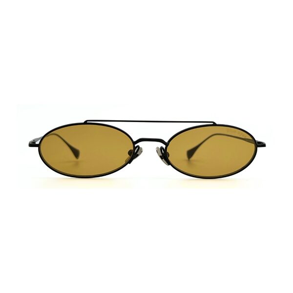 Homme au style urbain portant des lunettes de soleil BLUE EYES noires, monture fine à double pont et verres ambre clair.