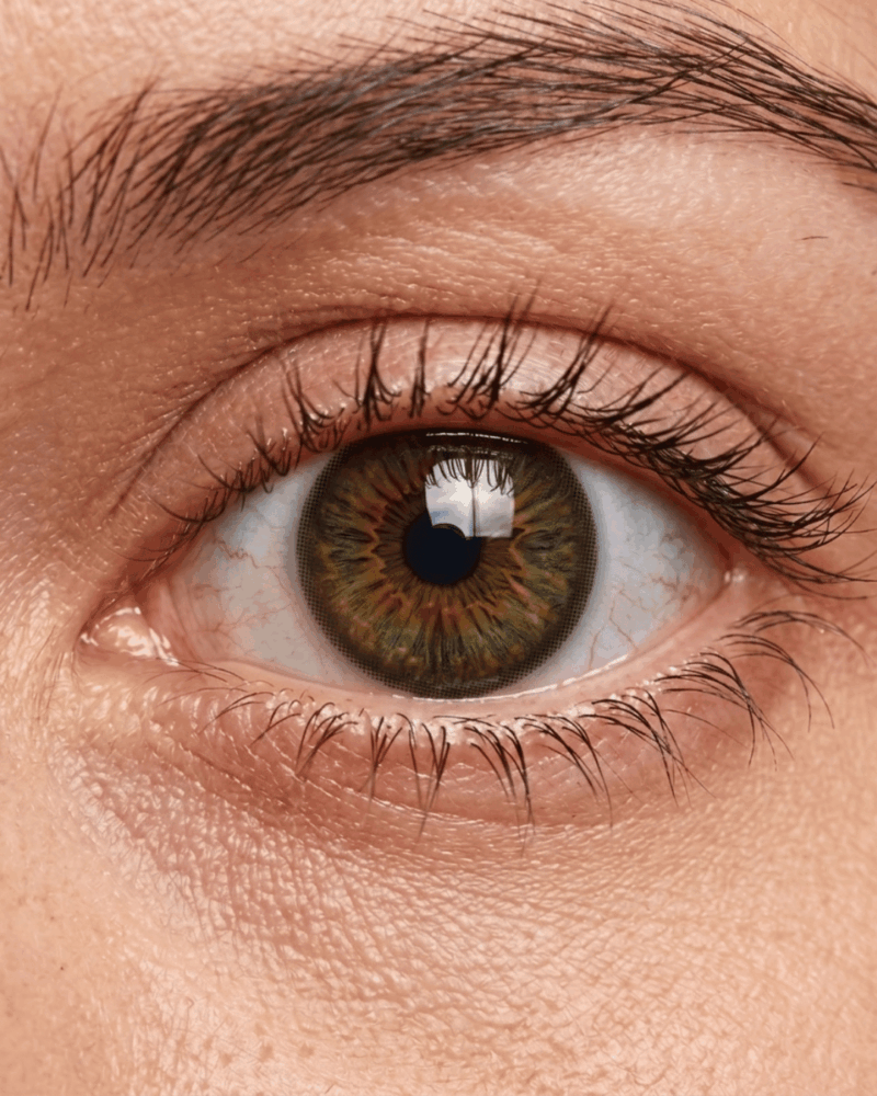 Gros plan d'un œil portant la lentille ADRIA Pure Hazel au fini noisette ambré naturel.