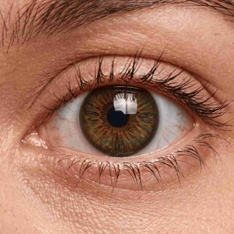 Gros plan d'un œil portant la lentille ADRIA Pure Hazel au fini noisette ambré naturel.