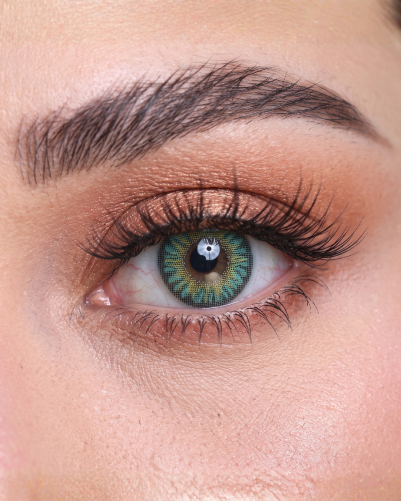 Gros plan macro détaillé d'un iris portant la lentille turquoise Soft Vision F-Turquoise révélant les micro-motifs lagon et le centre noisette