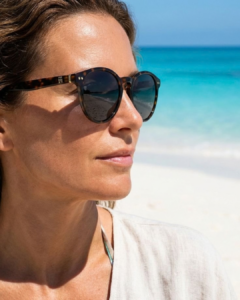Femme portant les solaires rétro pantos Tommy Hilfiger TH2159/S havana face à la mer Azzabi Optic