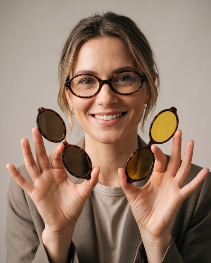 Femme souriante portant la lunette Kavak 1694 marron écaille avec les deux clips magnétiques en main