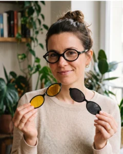 Femme portant la lunette Kavak 1694 noire forme ovale et présentant les deux clips magnétiques