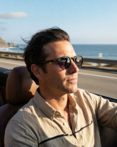 Lunettes de soleil Carrera 301/S Noir Homme - Allure Rétro-Pantos Homme portant les Lunettes de soleil Carrera 301/S rondes en acétate noir brillant en bord de mer