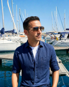 Homme portant les lunettes de soleil Carrera 1054/S 2M2/86 Noir et Or percées aviateur sur une marina