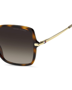Gros plan sur la charnière dorée et le drapeau émaillé Tommy Hilfiger sur la branche des lunettes TH2220/S