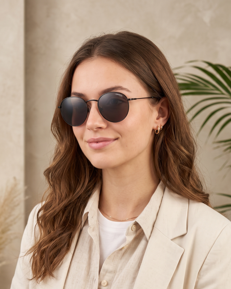 Femme portant les lunettes de soleil Carrera 246/S 00370 rondes en titane noir calibre 52 mm