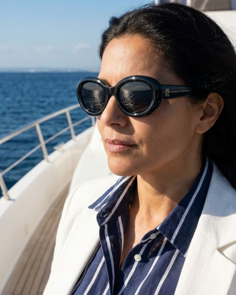Femme portant les lunettes de soleil Tommy Hilfiger TH 2207/S noir style chic bord de mer sur un bateau